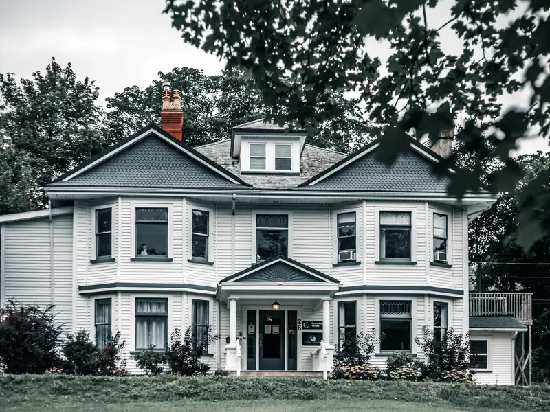 Large white house surrounded by mature trees